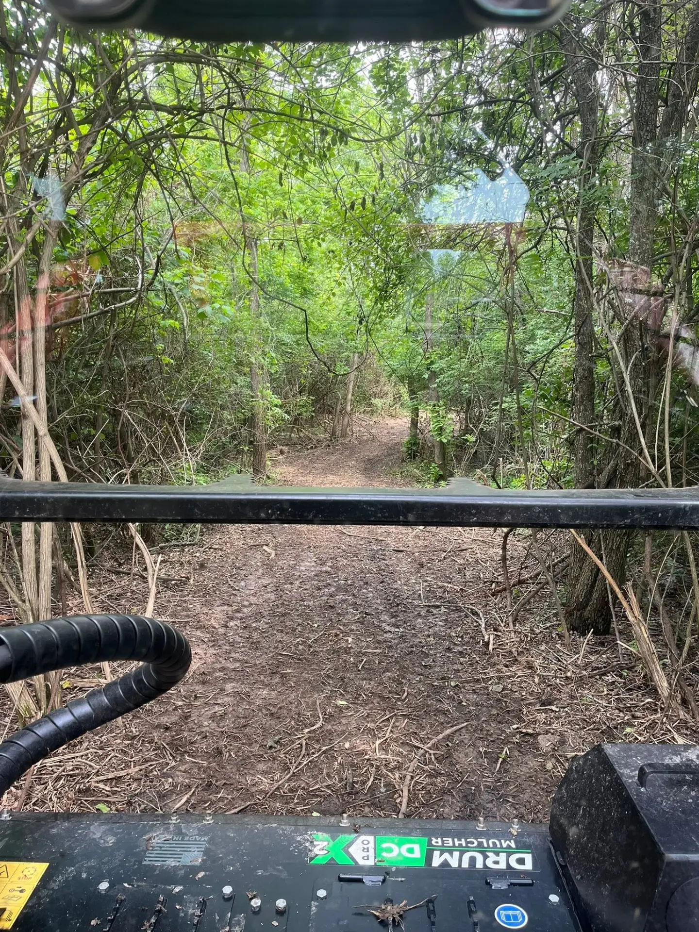View from the cab of a forestry mulcher cutting a trail through dense Ohio brush